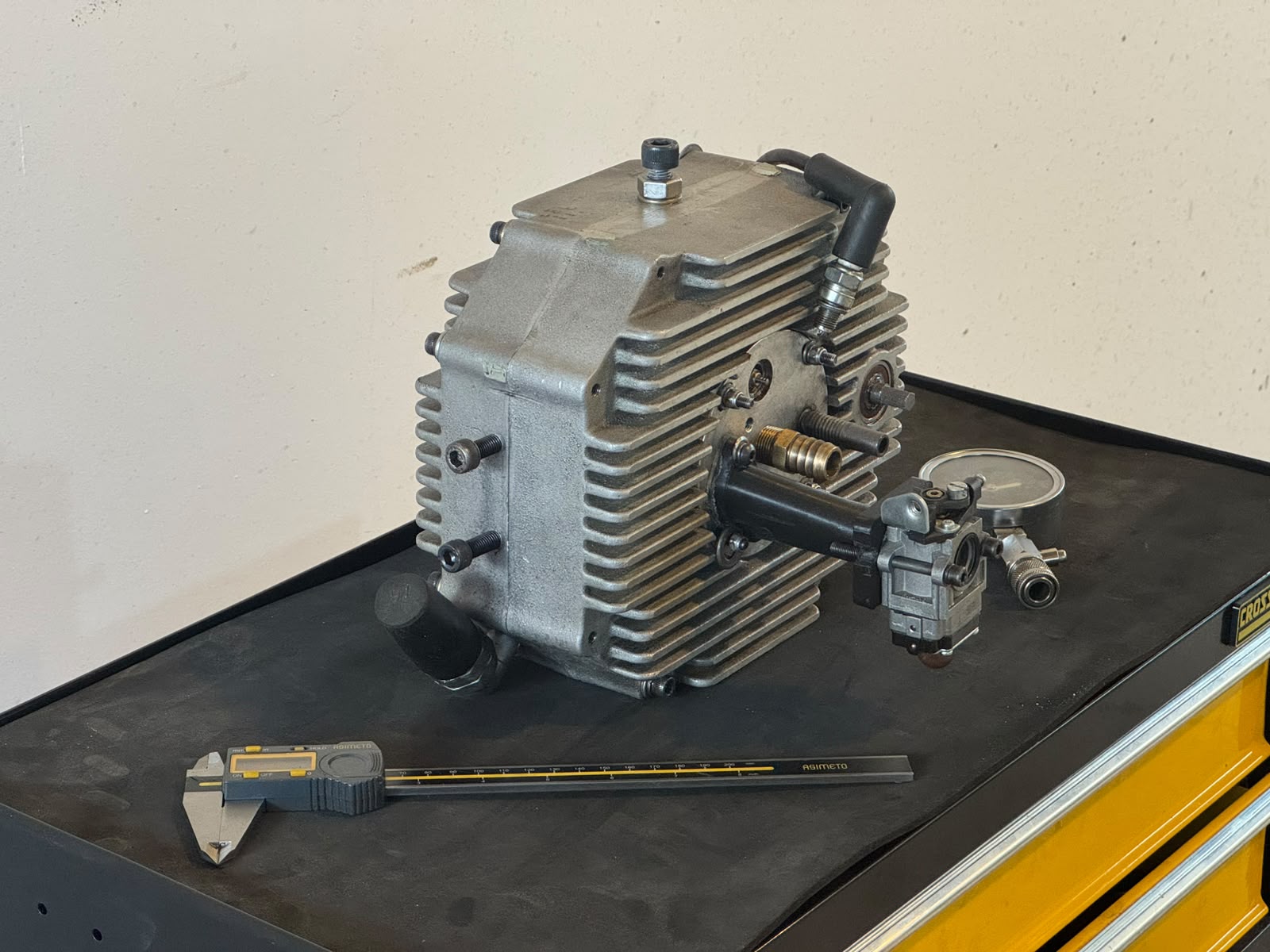 Bare 400 cc Engine Core on the workbench next to measurement instruments